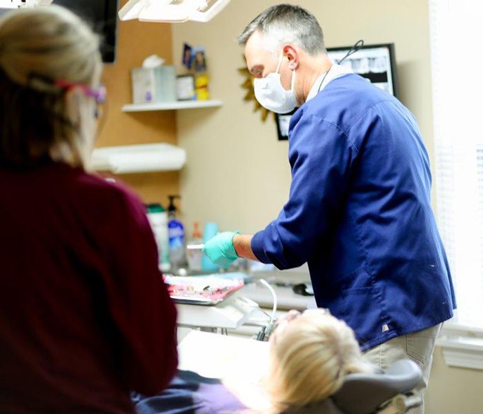 Dentist and team member treating dental patient during preventive dentistry visit