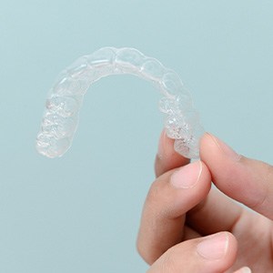 Closeup of patient holding clear aligner