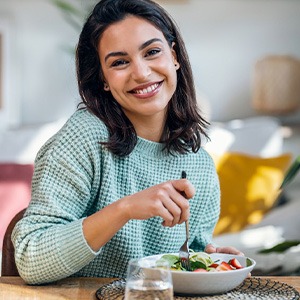 Smiling woman enjoying lunch at home