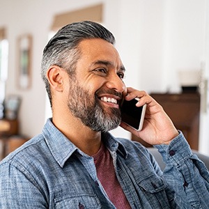 Man smiling while talking on phone at home