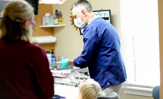 Dentist and team member talking to dental patient