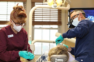 Dentist and team member treating dental patient