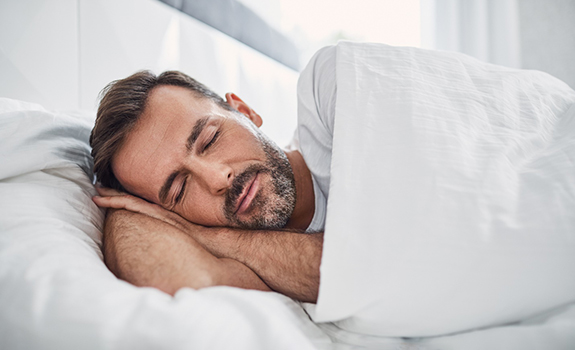 Man with sleep apnea in Rowley, MA sleeping in bed 