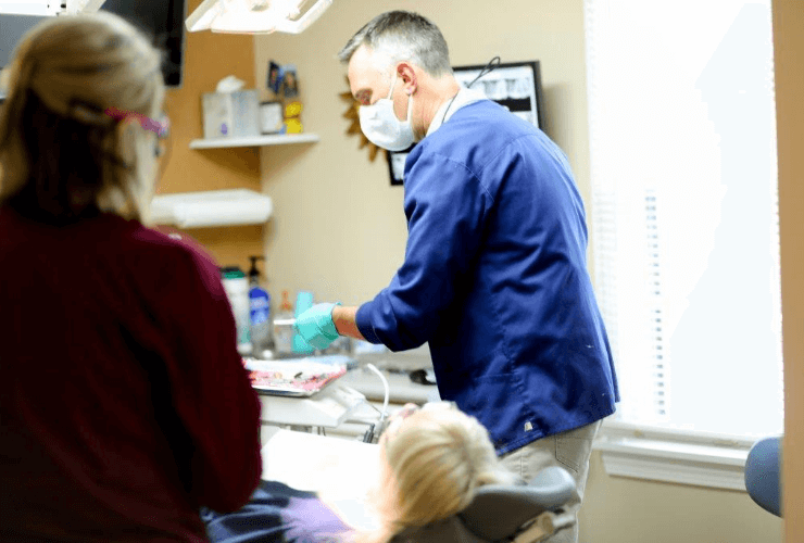 Doctor Saint Clair and dental team member treating patient