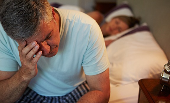 Frustrated man with sleep apnea waking feeling tired