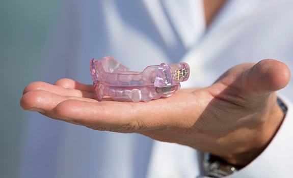 Hand holding a sleep apnea oral appliance