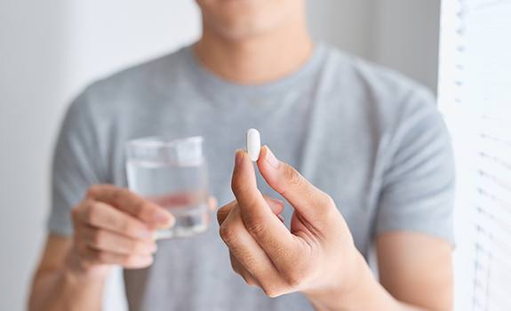 Patient holding an oral conscious dental sedation pill