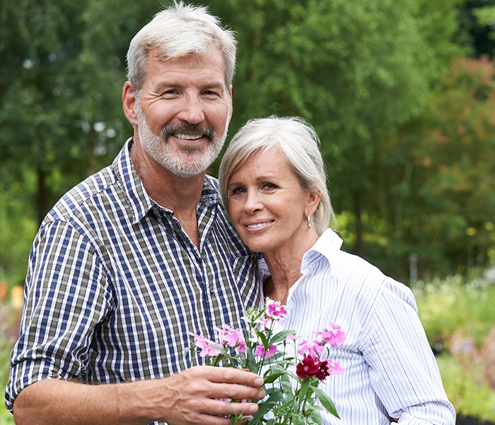 Older man and woman smiling after restorative dentistry