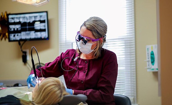 Dental team member examining patient during dental checkup and teeth cleaning visit