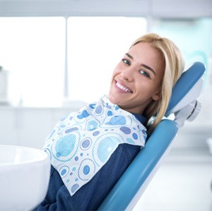 Female dental patient smiling and leaning back in chair