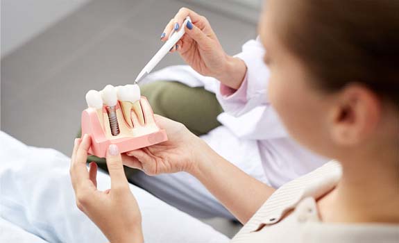 Patient holding model of dental implants in Rowley