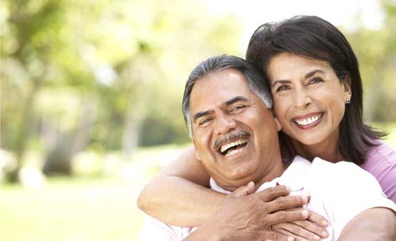 Couple with dental implants in Rowley smiling outside