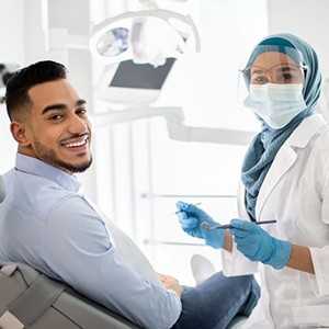 Happy dental patient smiling over his shoulder
