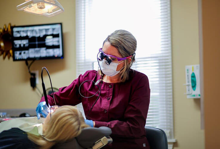 Dental team member treating dental patient