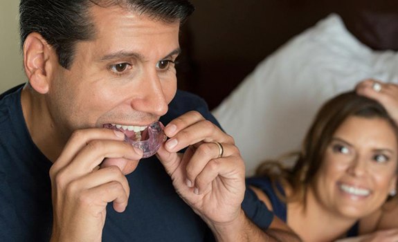 Man placing his sleep apnea oral appliance