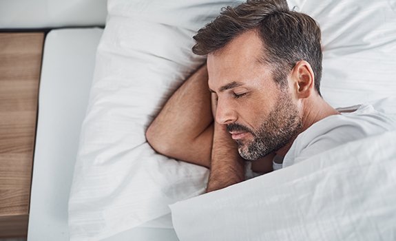 Man with sleep apnea oral appliance sleeping deeply