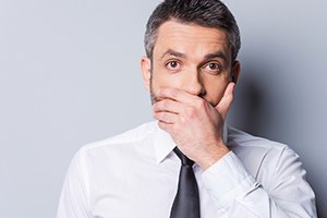 Man with lost tooth covering his mouth