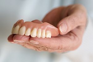 hand holding denture