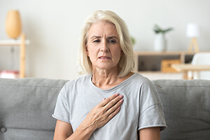 Woman suffering stroke holding her chest