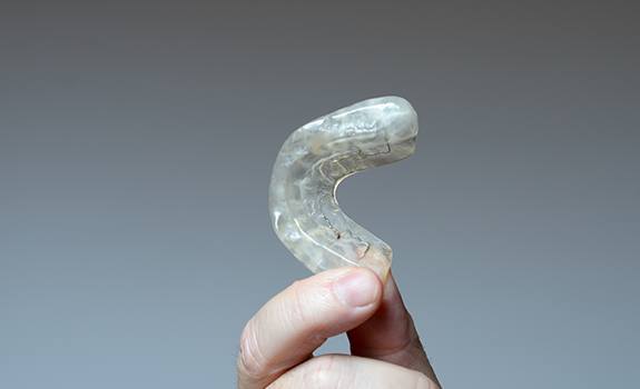 Hand holding a T M J occlusal splint