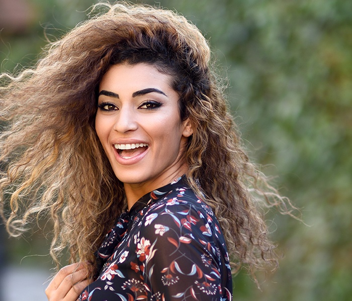 Woman with porcelain veneers showing off her smile