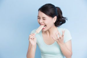 woman frowns biting into popsicle