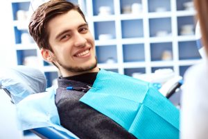 young man smiling dentist chair